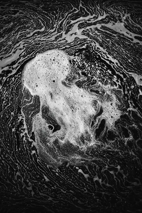 Close view of sea foam lace on dark water